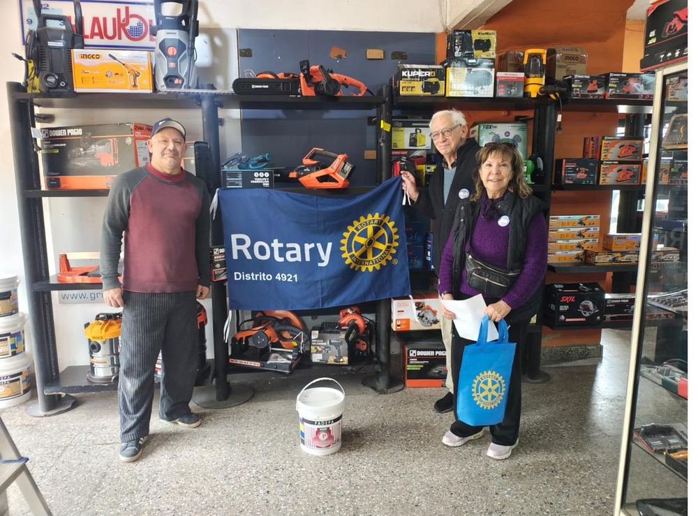 Socios del club con el estandarte en un comercio de la ciudad